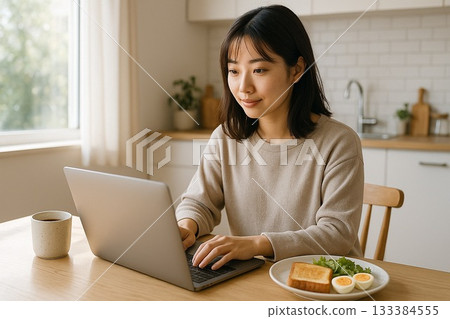 A woman eating breakfast while opening a laptop in the living room at home 133384555
