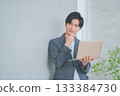 A man in office casual clothes holding a laptop 133384730