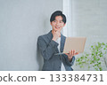 A man in office casual clothes holding a laptop 133384731