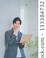 A man in office casual clothes holding a laptop 133384732