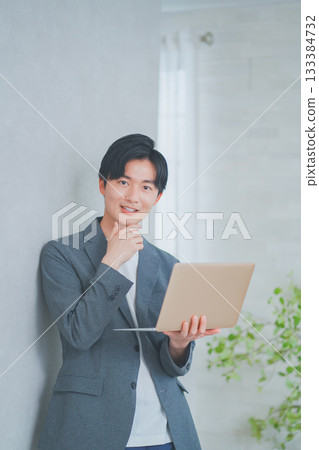 一名身穿商務休閒裝的男子手持筆記型電腦 133384732