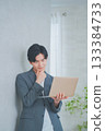 A man in office casual clothes holding a laptop 133384733