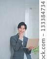 A man in office casual clothes holding a laptop 133384734