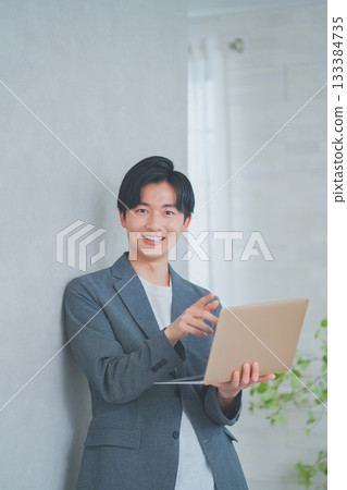 一名身穿商務休閒裝的男子手持筆記型電腦 133384735