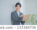 A man in office casual clothes holding a laptop 133384736