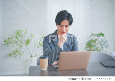 A man in office casual clothes having a meeting while drinking coffee A man in office casual clothes having a meeting while drinking coffee 133384738