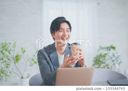 A man in office casual clothes having a meeting while drinking coffee A man in office casual clothes having a meeting while drinking coffee 133384743