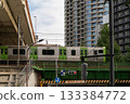 Train passing over a bridge in a modern Japanese city 133384772