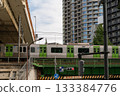 Train passing over a bridge in a modern Japanese city 133384776