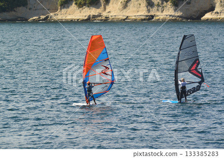August 21, 2023, Zushi/Hayama, Kanagawa Prefecture: A colorful tandem windsurfer glides across the ocean. August 21, 2023, Zushi/Hayama, Kanagawa Prefecture: A colorful tandem windsurfer glides across the ocean. 133385283