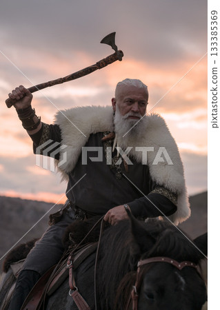 A fierce Viking warrior on horseback, wielding an axe, stands against a dramatic sunset sky with clouds and mountains, embodying strength, exploration, and ancient legend. A fierce Viking warrior on horseback, wielding an axe, stands against a dramatic sunset sky with clouds and mountains, embodying strength, exploration, and ancient legend. 133385369