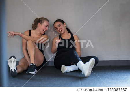 Friends enjoying a light moment after an intense workout at the gym 133385587