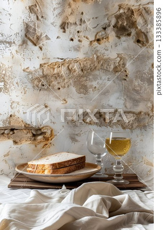 A slice of bread is placed on a plate beside two wine glasses, rustic table with bread and wine for Jerusalem Day celebration 133385896