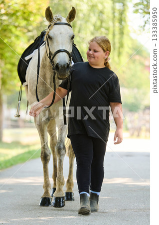 Girl walking with her horse in nature, outdoor scene, equestrian lifestyle, friendship with animal, happy child with horse, sunny day, summer activity, countryside life Girl walking with her horse in nature, outdoor scene, equestrian lifestyle, friendship with animal, happy child with horse, sunny day, summer activity, countryside life 133385950