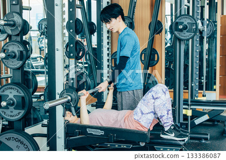 A woman training her arms at the training gym A woman training her arms at the training gym 133386087