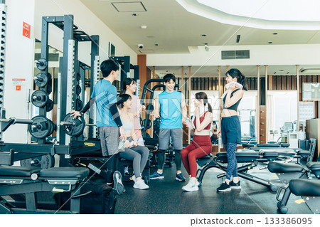Men and women exercising at a fitness gym Men and women exercising at a fitness gym 133386095