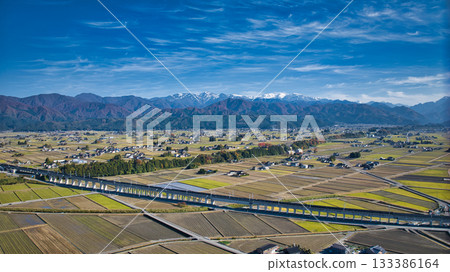 這是富山縣入禪町附近高架橋旁的北陸新幹線景色,背景是北阿爾卑斯山脈。 這是富山縣入禪町附近高架橋旁的北陸新幹線景色,背景是北阿爾卑斯山脈。 133386164