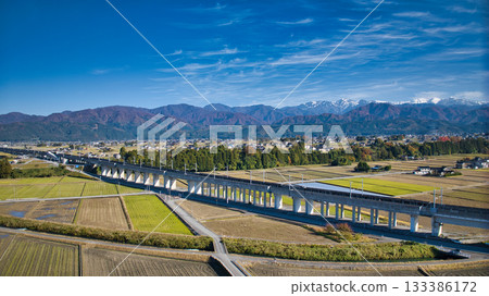 A view of the Hokuriku Shinkansen line near the viaduct running through Nyuzen Town, Toyama Prefecture, with the Northern Alps in the background A view of the Hokuriku Shinkansen line near the viaduct running through Nyuzen Town, Toyama Prefecture, with the Northern Alps in the background 133386172
