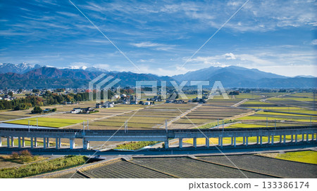 A view of the Hokuriku Shinkansen line near the viaduct running through Nyuzen Town, Toyama Prefecture, with the Northern Alps in the background A view of the Hokuriku Shinkansen line near the viaduct running through Nyuzen Town, Toyama Prefecture, with the Northern Alps in the background 133386174