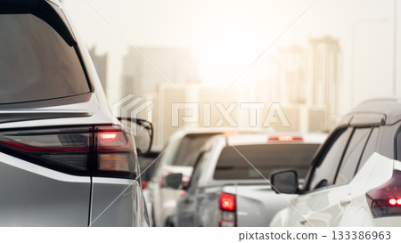 Rear side of grey car driving on the road. Enveronment traffic jam in the city with heavy pollution. Dense fog surrounds a major city. Cars lined up during rush hour. 133386963