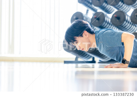 Young man doing push-ups in a training gym 133387230