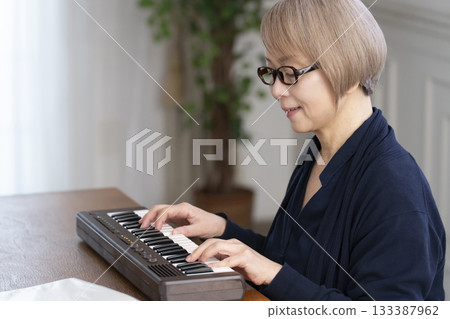 Senior woman playing keyboard 133387962