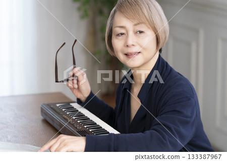 一位老年婦女彈奏鍵盤 一位老年婦女彈奏鍵盤 133387967