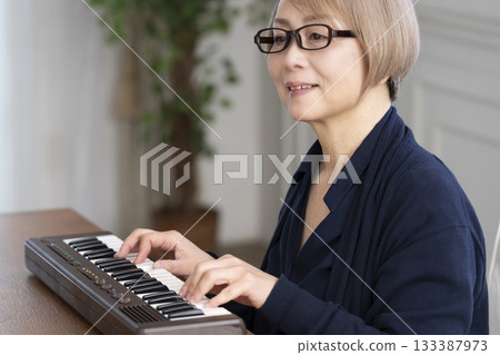 一位老年婦女彈奏鍵盤 133387973