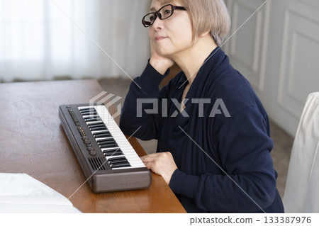 一位老年婦女彈奏鍵盤 133387976
