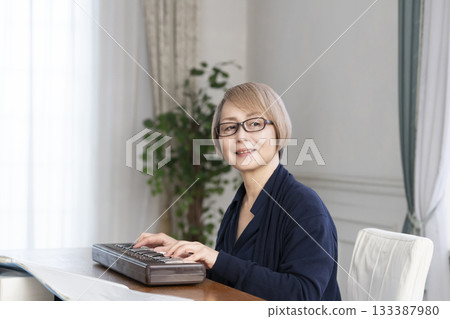 一位老年婦女彈奏鍵盤 一位老年婦女彈奏鍵盤 133387980