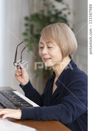 一位老年婦女彈奏鍵盤 133387989