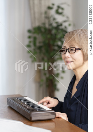 一位老年婦女彈奏鍵盤 133388002