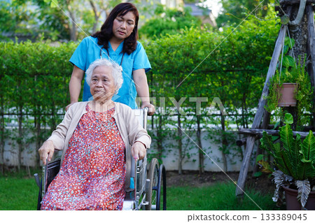 Doctor help Asian elderly woman disability patient walk with walker in park, medical concept. Doctor help Asian elderly woman disability patient walk with walker in park, medical concept. 133389045
