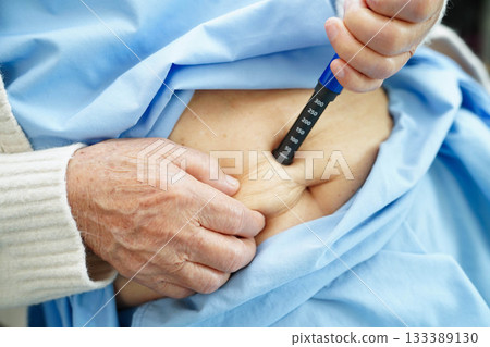 Asian senior woman making injection insulin pen in belly to treatment diabetes. Asian senior woman making injection insulin pen in belly to treatment diabetes. 133389130