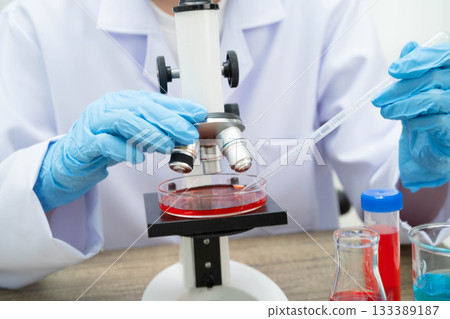 Scientist medical professional use microscope for research in science laboratory. 133389187