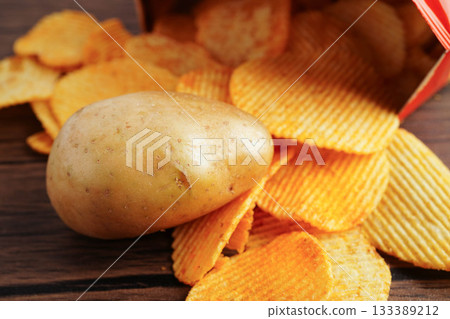 Potato chips in open bag, delicious BBQ seasoning spicy for crips, thin slice deep fried snack fast food. Potato chips in open bag, delicious BBQ seasoning spicy for crips, thin slice deep fried snack fast food. 133389212