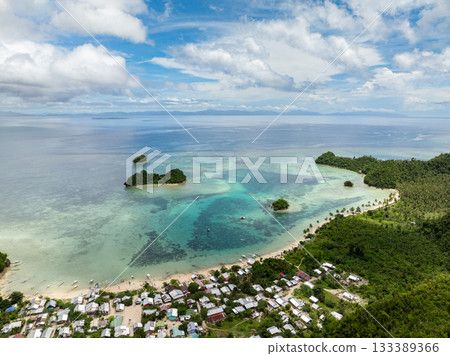 Village by the beach with turquoise lagoon and coral reef in clear tropical water. Siargao, Philippines. Sugba Blue Lagoon. 133389366