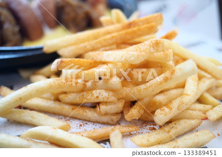 Crispy French fries with a sprinkle of seasoning served hot 133389451
