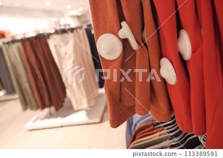 Colorful clothing with security tag display in a modern retail store 133389591