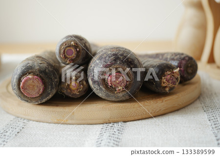 Fresh black carrots on a wooden cutting board Fresh black carrots on a wooden cutting board 133389599
