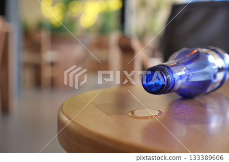 Blue bottle spills on wooden table in a cafe 133389606