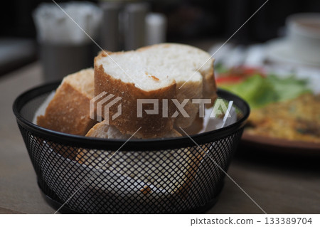 Freshly baked bread served in a basket at a cafe Freshly baked bread served in a basket at a cafe 133389704