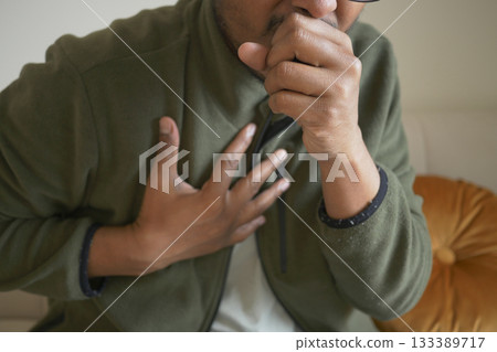 Man experiencing chest pain while sitting indoors 133389717