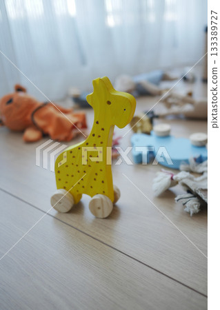 Bright yellow wooden toy giraffe on a floor  133389727