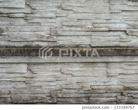 a fragment of an old, dilapidated, mossy concrete-stone fence with a rough, destroyed texture of the masonry, green traces of wet moss and an uneven structure of the stone layers a fragment of an old, dilapidated, mossy concrete-stone fence with a rough, destroyed texture of the masonry, green traces of wet moss and an uneven structure of the stone layers 133389767