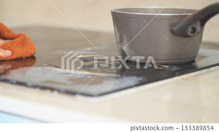 wiping electric stovetop with with cloth wiping electric stovetop with with cloth 133389854