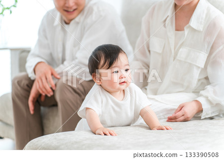 Smiling family with baby standing up on sofa Smiling family with baby standing up on sofa 133390508
