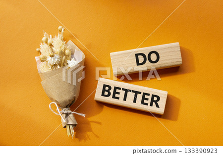 Do better symbol. Wooden blocks with words Do better. Beautiful orange background with bouquet of flowers. Business and Do better concept. Copy space. Do better symbol. Wooden blocks with words Do better. Beautiful orange background with bouquet of flowers. Business and Do better concept. Copy space. 133390923