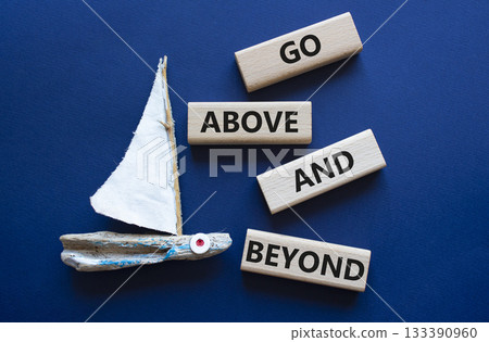 Go above and beyond symbol. Wooden blocks with words Go above and beyond. Beautiful deep blue background with boat. Business concept. Copy space. Go above and beyond symbol. Wooden blocks with words Go above and beyond. Beautiful deep blue background with boat. Business concept. Copy space. 133390960