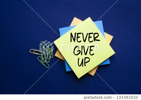 Never give up symbol. Sticky notes with Concept words Never give up. Beautiful deep blue background. Business and Never give up concept. Copy space. 133391010